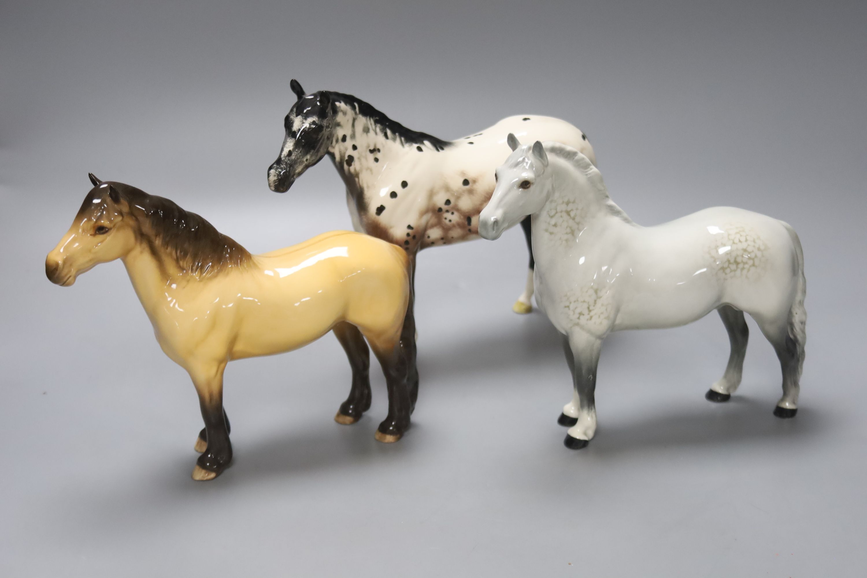 A Beswick Highland pony, a Beswick grey horse and a Royal Doulton Apaloosa, tallest 20cm